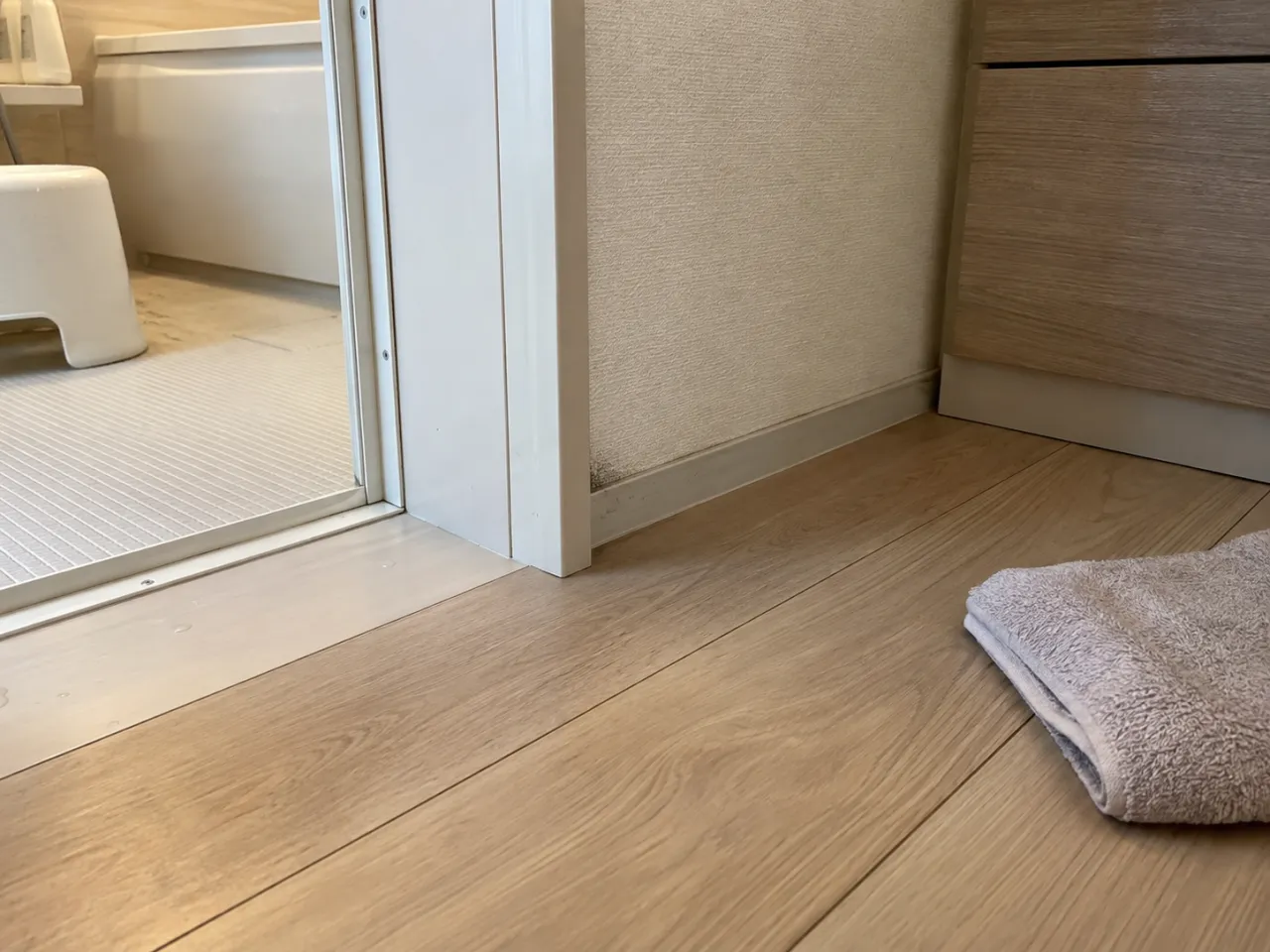 浴室ドアの床濡れについて電話で相談する様子